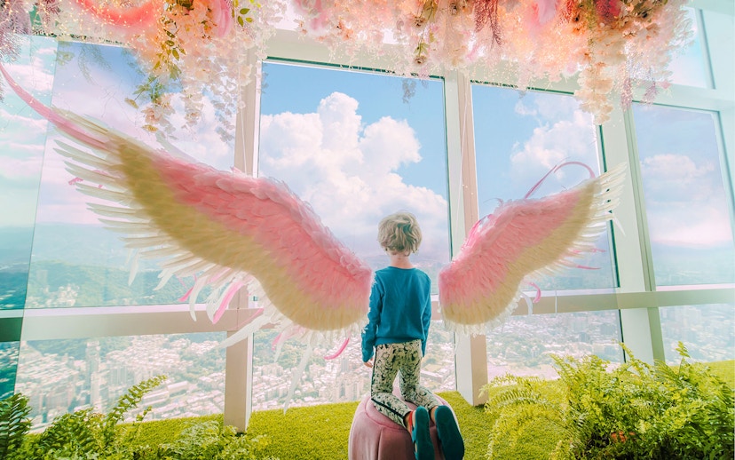 Child with angel wings overlooking Taipei from Taipei 101 observatory.