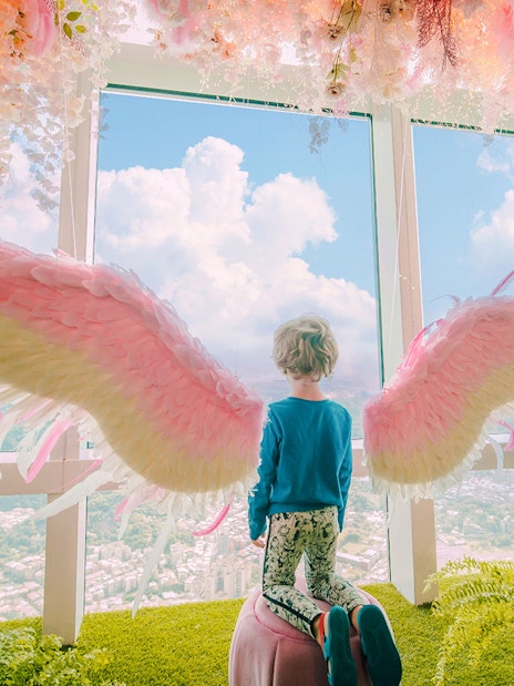 Child with angel wings overlooking Taipei from Taipei 101 observatory.