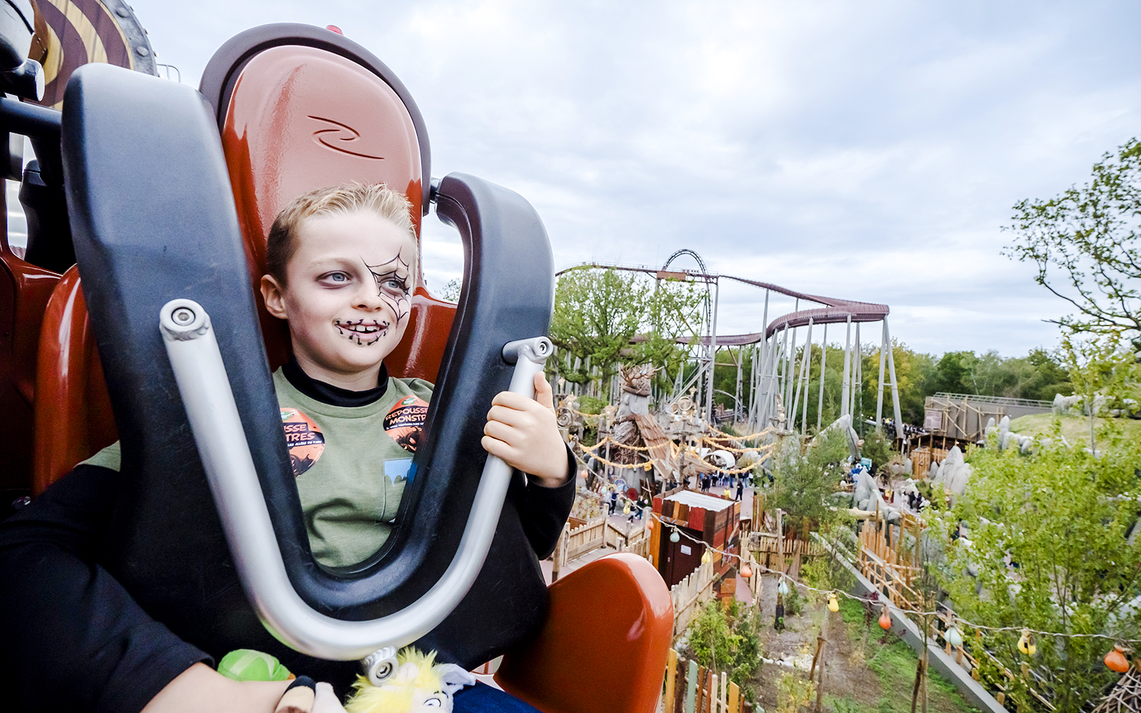 Child with face paint on a ride during Halloween at Parc Asterix.
