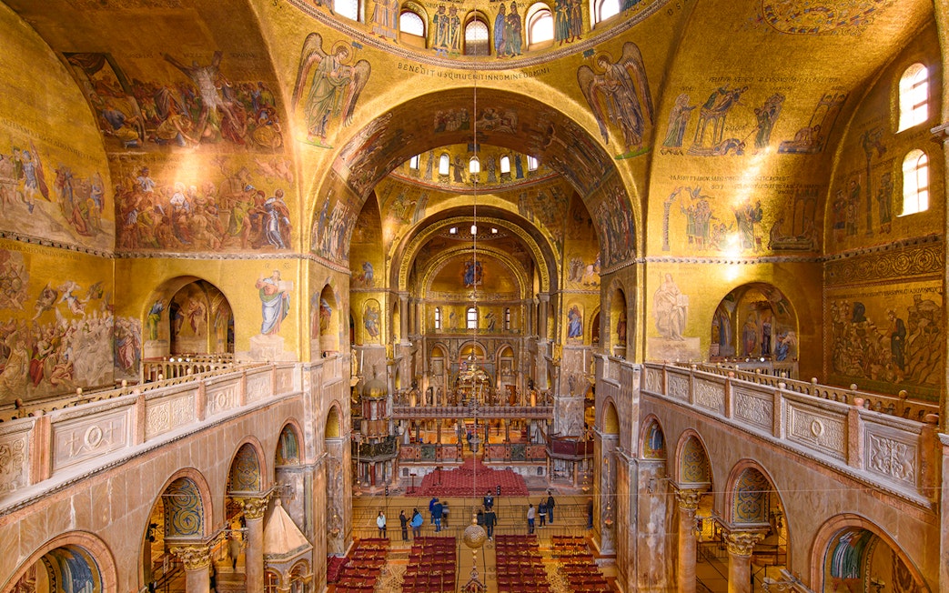 Interior of St. Mark's Basilica in Venice, showcasing ornate mosaics and architecture.