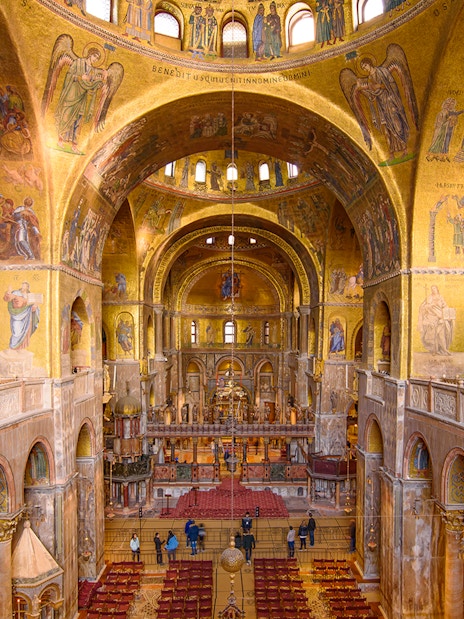 Interior of St. Mark's Basilica in Venice, showcasing ornate mosaics and architecture.