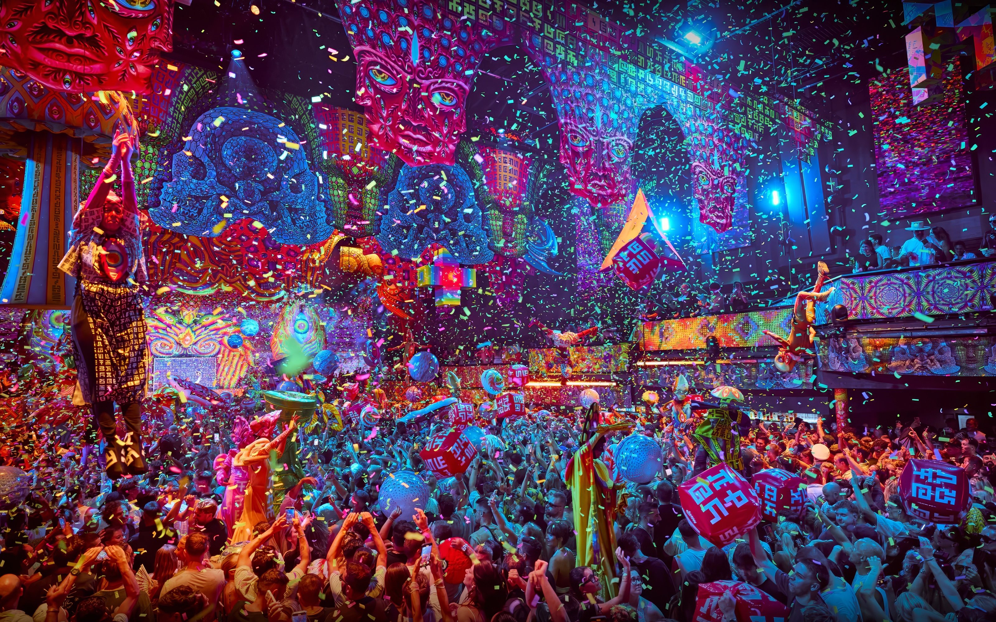Crowd enjoying vibrant elRow performance with confetti and colorful decor in Ibiza.