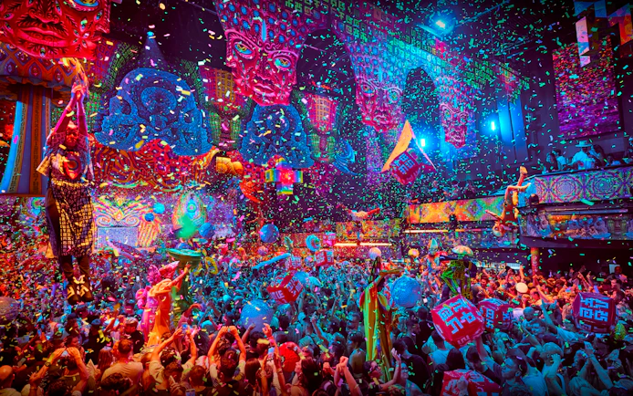 Crowd enjoying vibrant elRow performance with confetti and colorful decor in Ibiza.