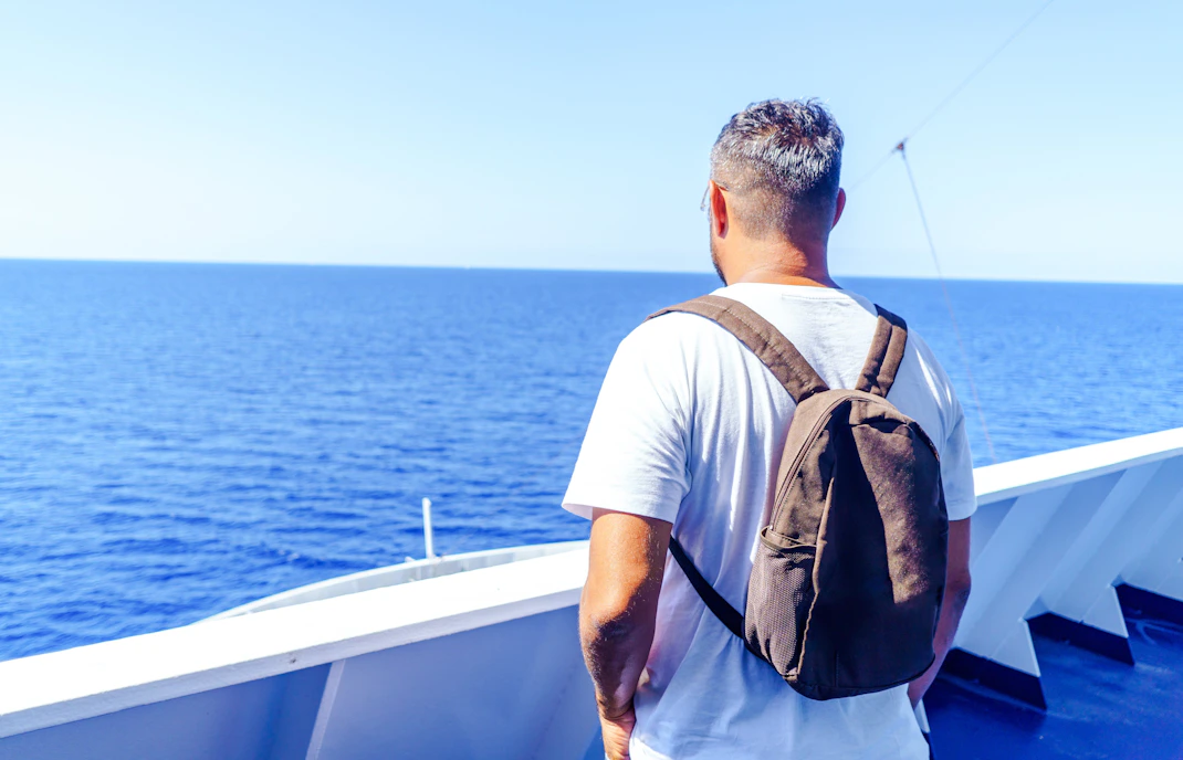Man with backpack on Formentera cruise from Ibiza, October.
