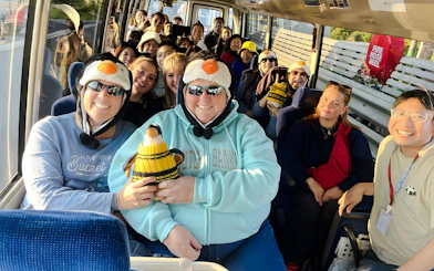 Tourists wearing penguin hats on a coach to Phillip Island.