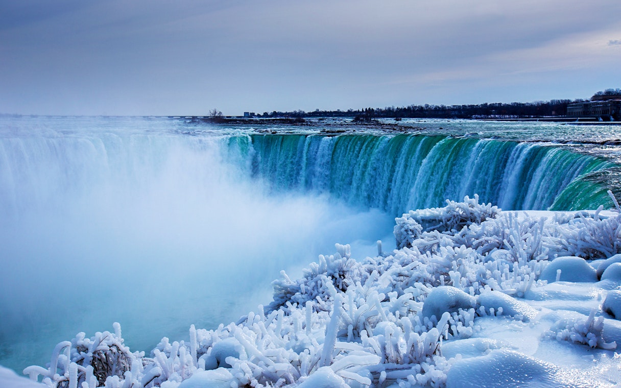 Niagara Falls in winter with icy formations and flowing water.