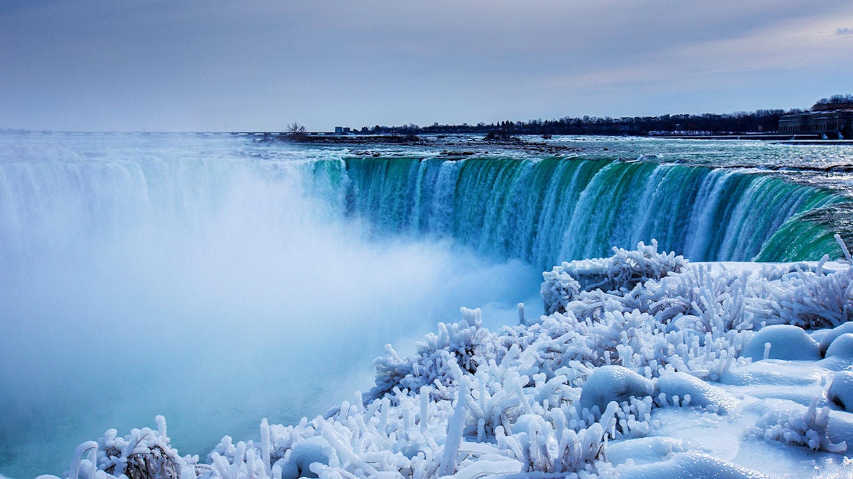 Niagara Falls winter view with snow-covered landscape and Cave of the Winds tour access.
