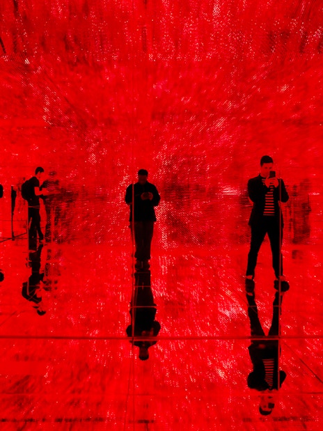 Visitors exploring immersive red light exhibit at Mercer Labs, Museum of Art & Technology.