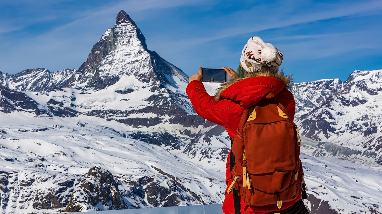 Tourist photographing Matterhorn mountain in the Swiss Alps.