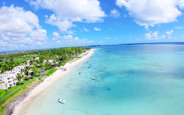 Aerial view of Mauritius coastline with seaplane over turquoise waters on Short Amber Route Scenic Tour.