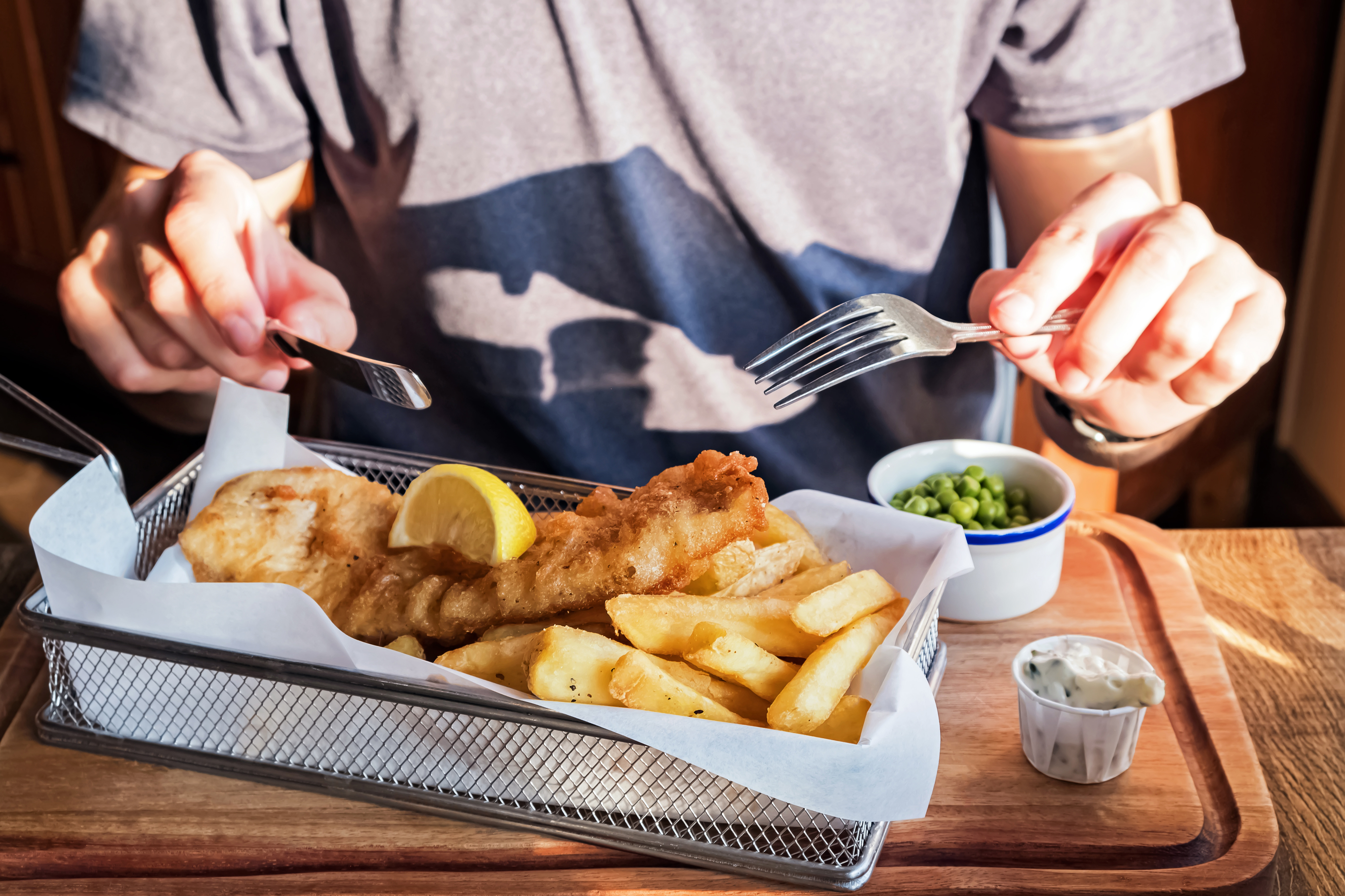 Man eating fish and chips at restaurant inside Alnwick Castle