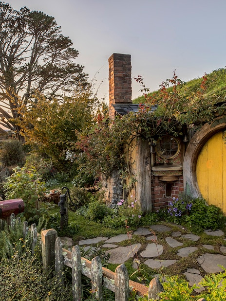 Hobbiton Movie Set with yellow round door and garden in Matamata, New Zealand.