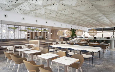 Lounge seating area at Istanbul Ataturk Airport with modern decor and dining tables.
