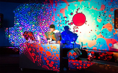 DJ performing at Nightlife event, California Academy of Sciences, with vibrant psychedelic visuals.