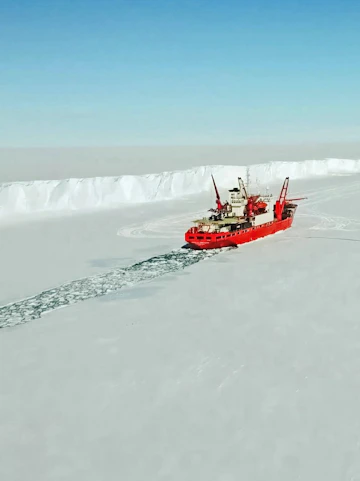 Ice Enpalled Naldo icebreaker ship navigating through Arctic ice.