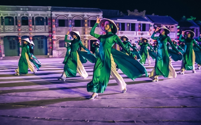 Performers in traditional attire dancing at Hoi An Memories Show, Vietnam.