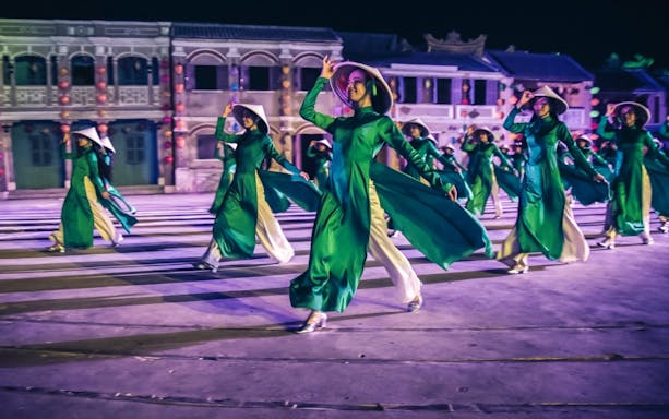 Performers in traditional attire dancing at Hoi An Memories Show, Vietnam.