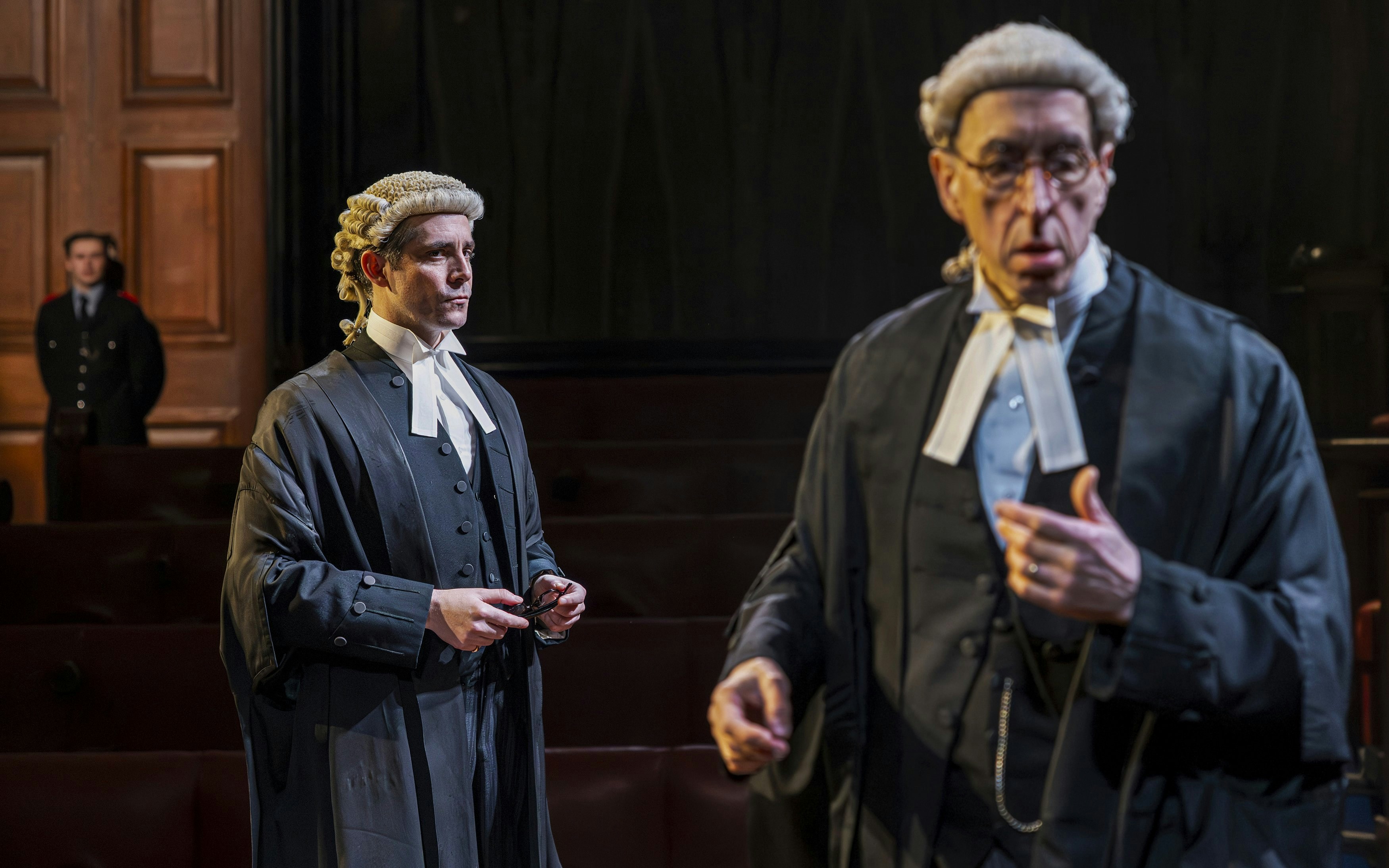 Cast of "Witness for the Prosecution" in courtroom attire on West End stage.