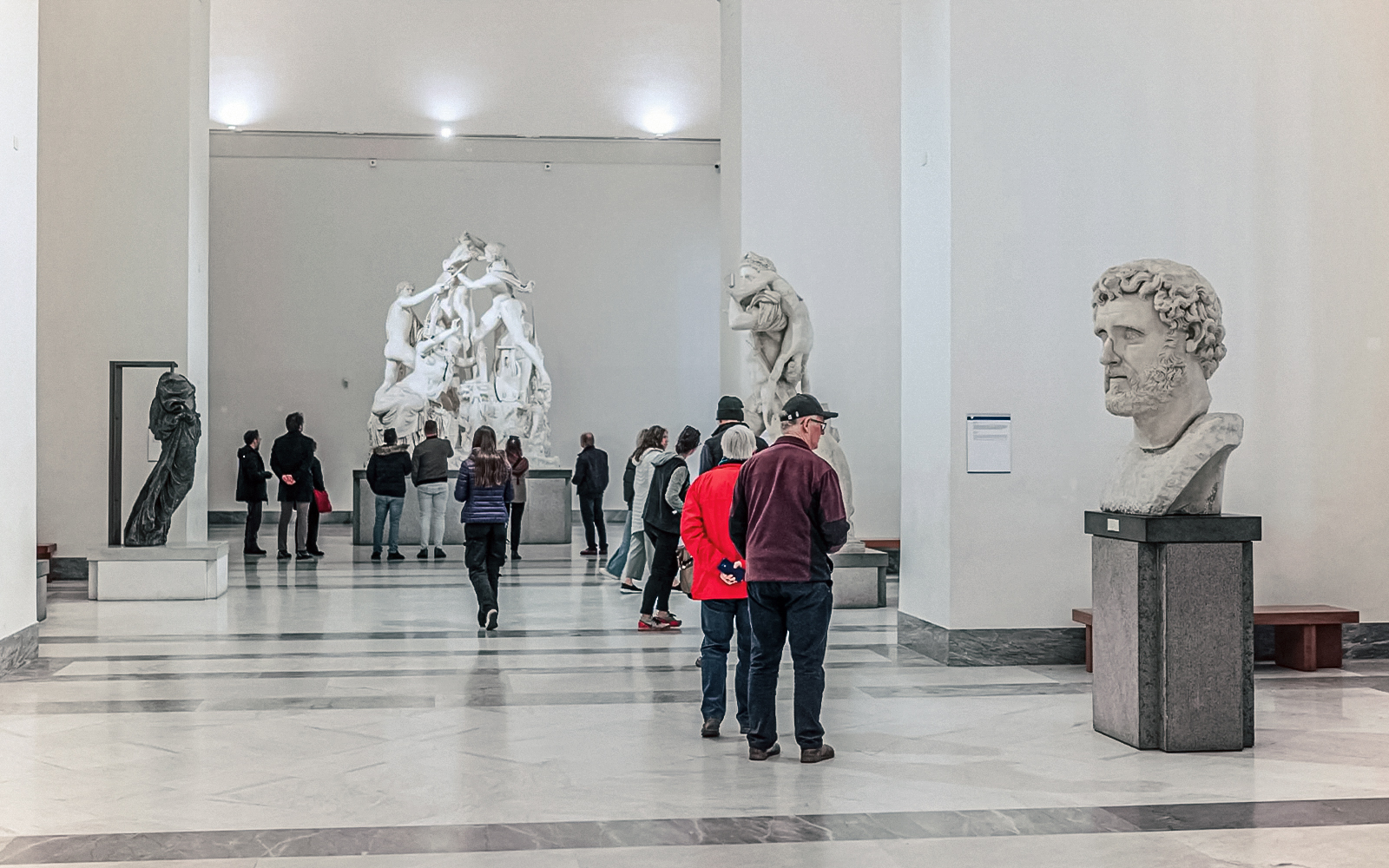 Visitors exploring sculptures at the National Archaeological Museum in Naples.
