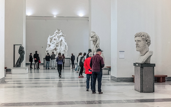 Visitors exploring sculptures at the National Archaeological Museum in Naples.