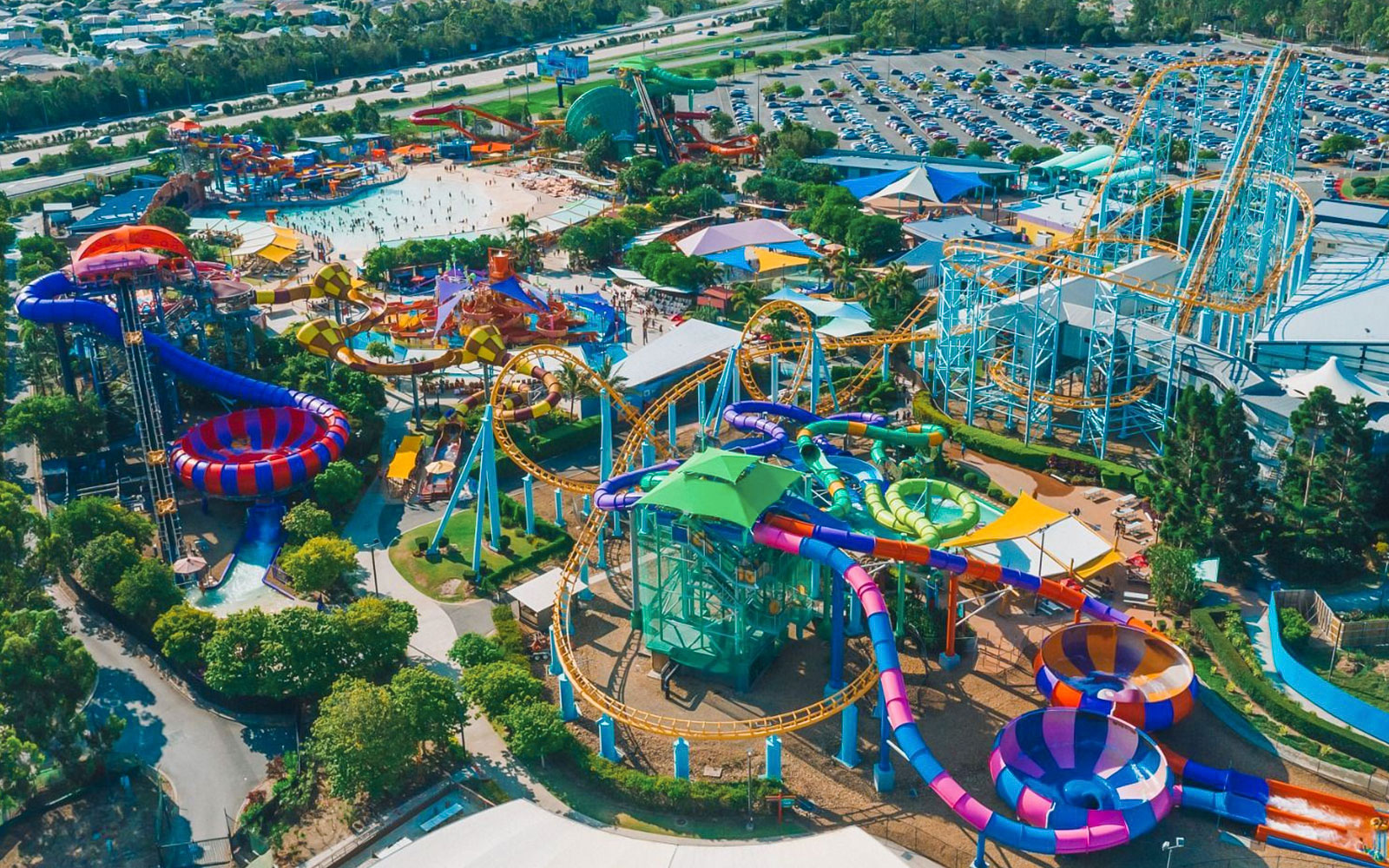 Aerial view of Dreamworld and WhiteWater World theme parks with colorful water slides and roller coasters.