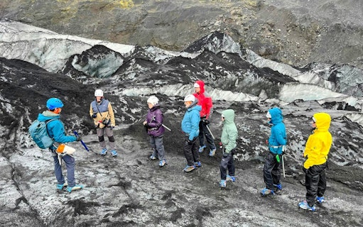 Guests hiking on Sólheimajökull Glacier in Iceland with a guide.