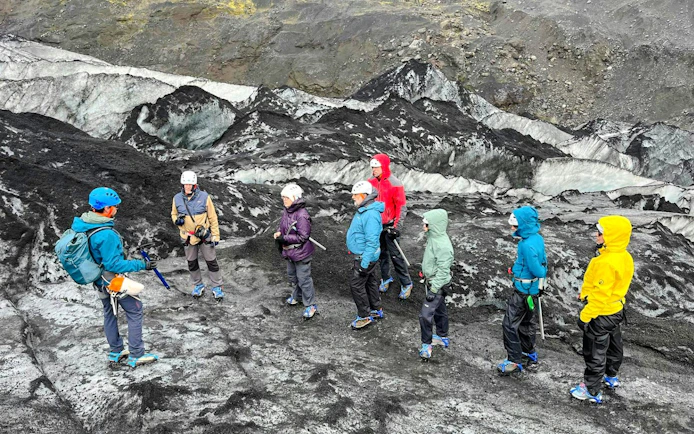 Guests hiking on Sólheimajökull Glacier in Iceland with a guide.