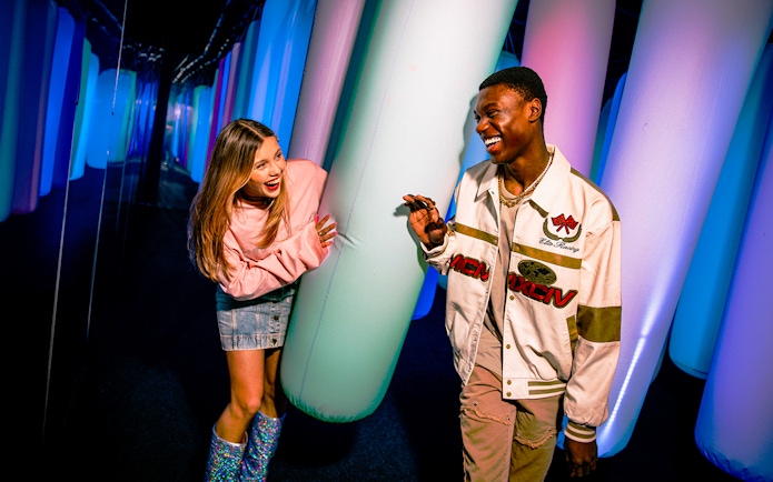 Visitors enjoying colorful inflatable pillars at WONDR Experience.