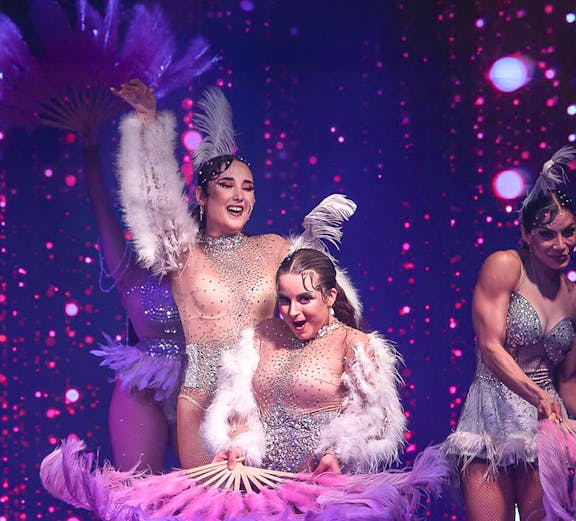 Cabaret dancers with feather fans performing at La Scène Dinner Show in Prague.