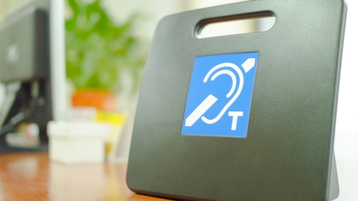 Hearing loop T-position system sign on a desk for the Deaf.