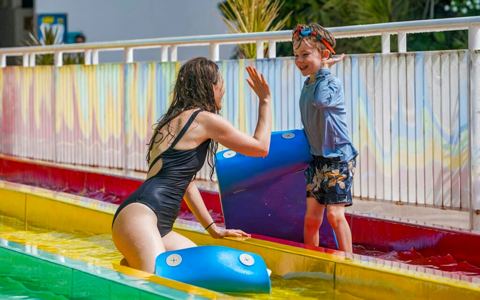 Child and adult enjoying water slide at Splash Water Park, FINNS Beach Club Bali.