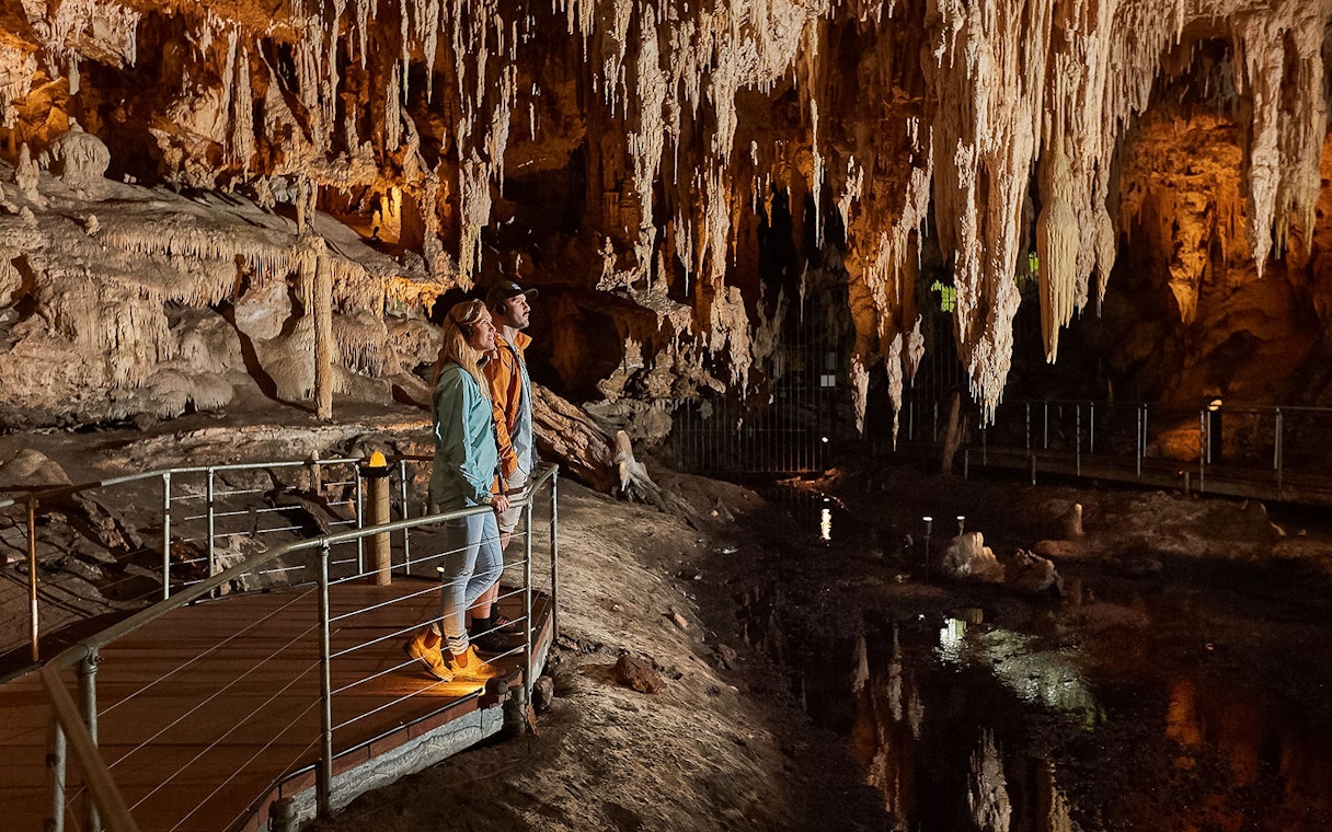 Visitors exploring stalactites in Mammoth Cave, Margaret River on a self-guided audio tour.