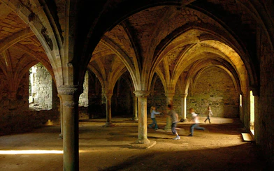 Children playing in the vaulted undercroft of Battle Abbey, England.