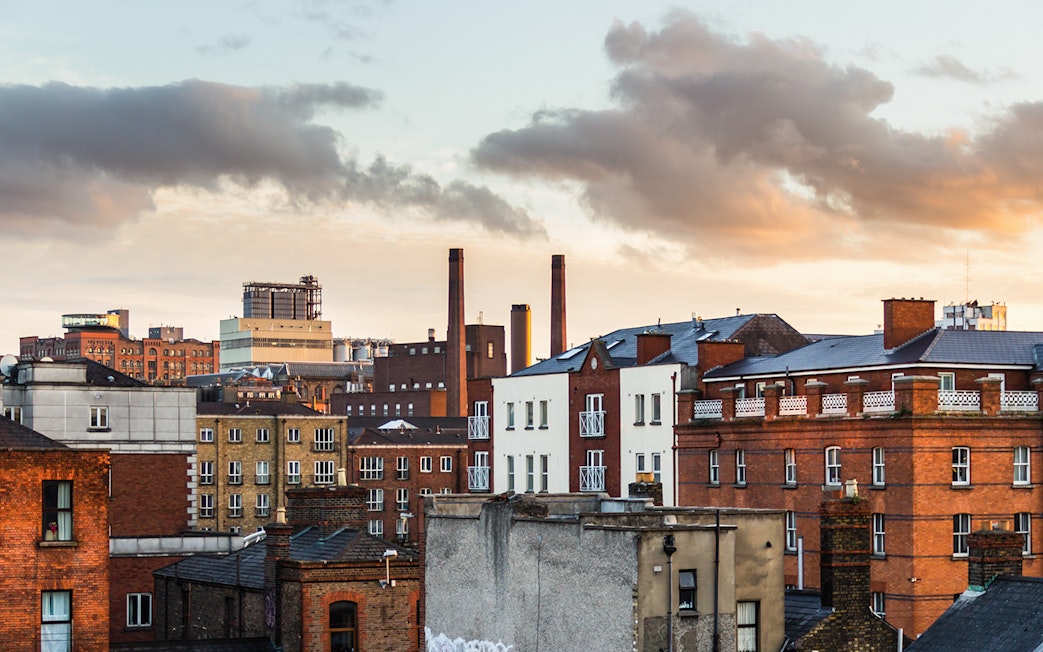 Dublin cityscape with historic brick buildings and chimneys at sunset.