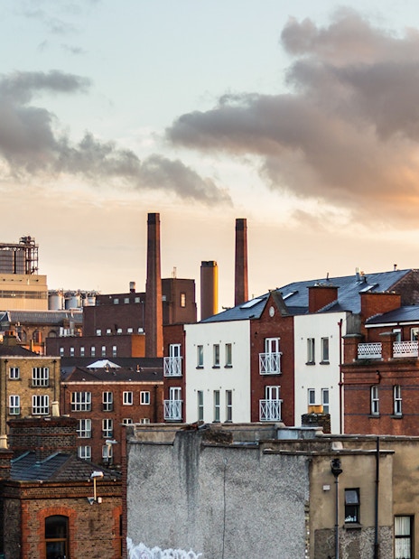 Dublin cityscape with historic brick buildings and chimneys at sunset.