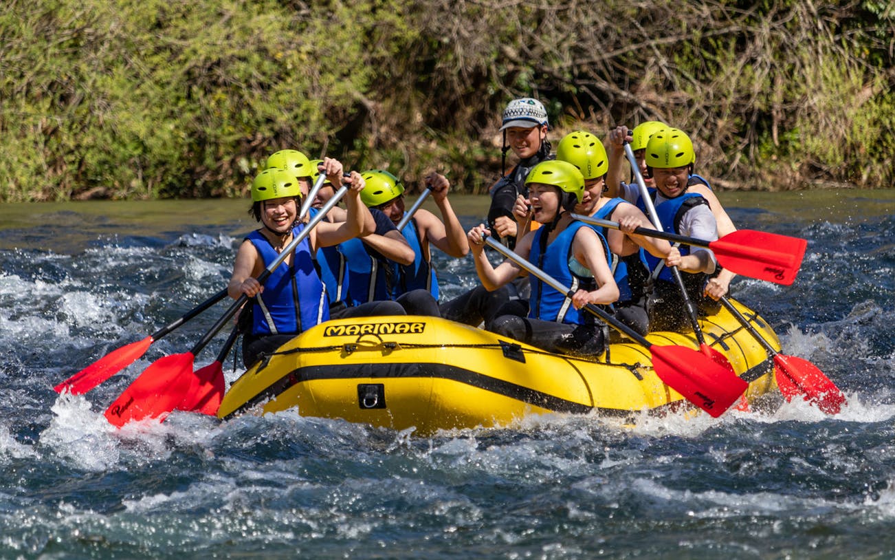 Group rafting on the Cetina River in a yellow raft with red paddles.