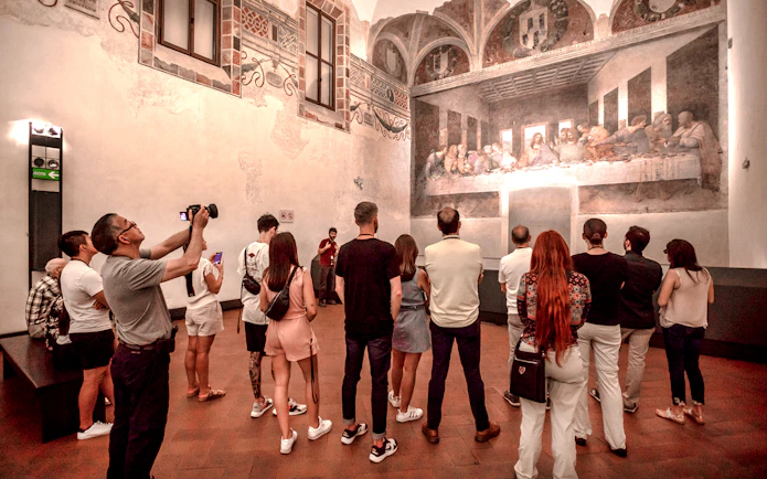 Tourists viewing The Last Supper mural inside Santa Maria delle Grazie, Milan.