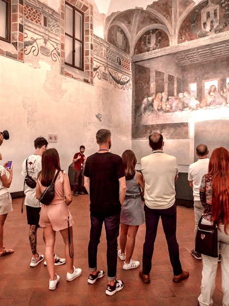 Tourists viewing The Last Supper mural inside Santa Maria delle Grazie, Milan.
