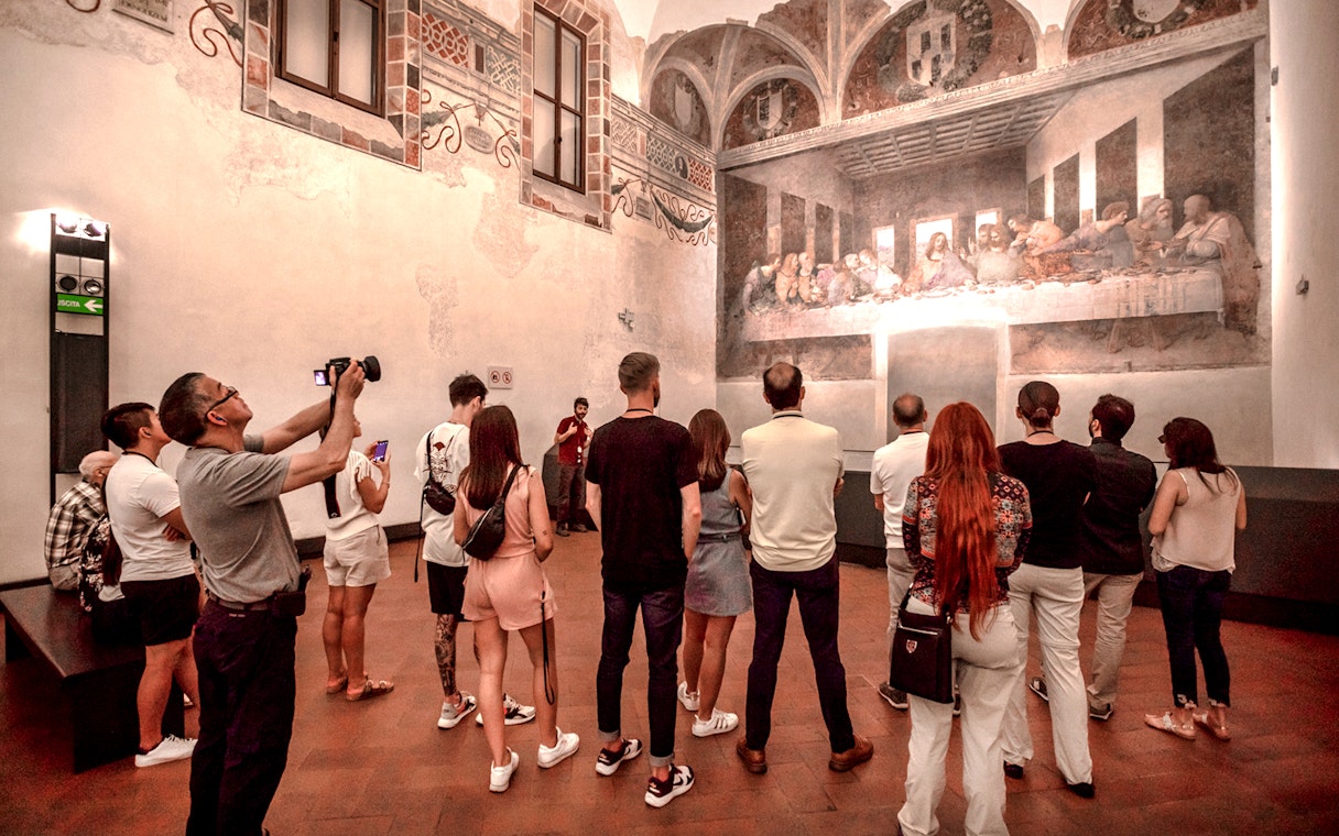 Tourists viewing The Last Supper mural inside Santa Maria delle Grazie, Milan.