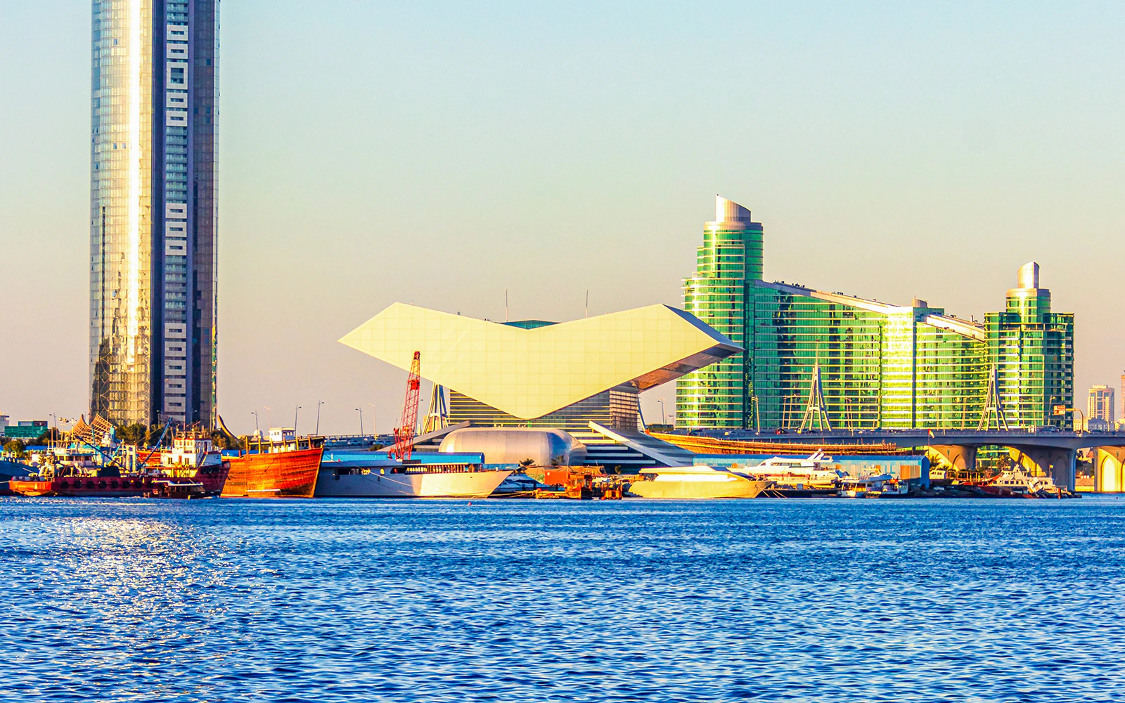 Mohammed bin Rashid Library by Dubai Creek with modern architecture and nearby skyscrapers.