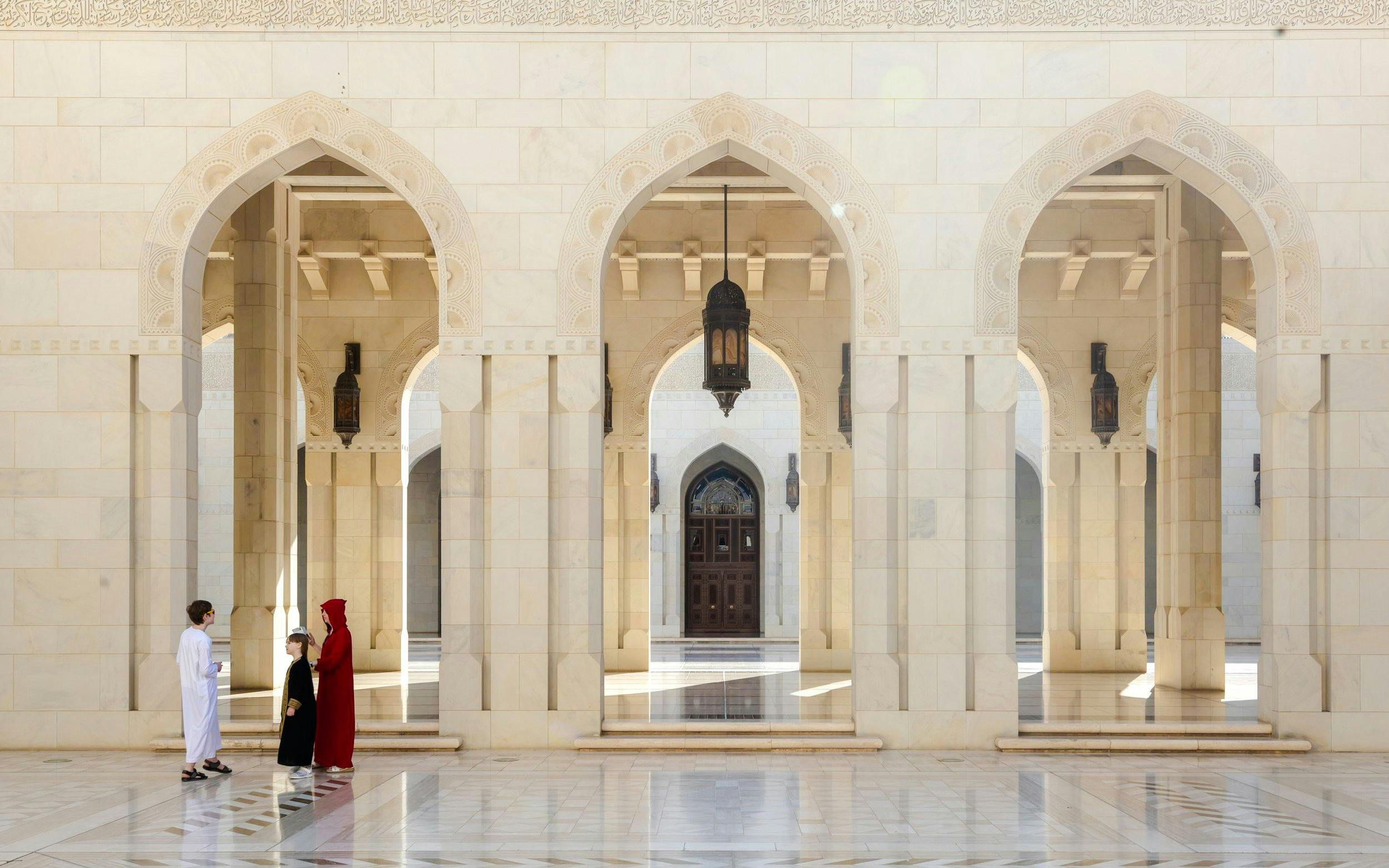 Guide interacting with tourists in the courtyard of the Royal Opera House, Muscat.