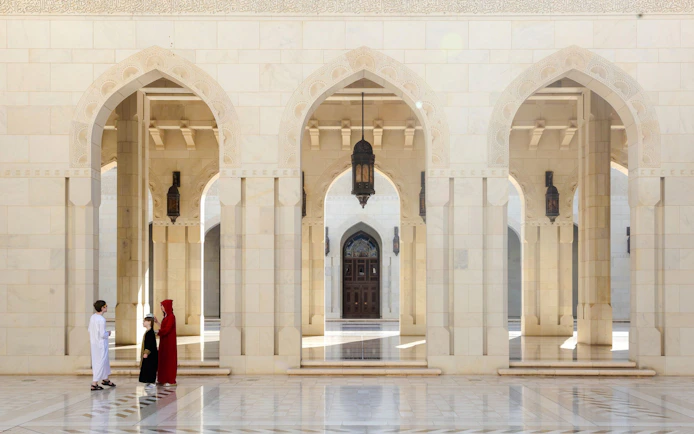 Guide interacting with tourists in the courtyard of the Royal Opera House, Muscat.