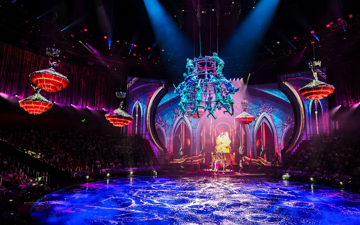 Acrobats performing above water stage during House of Dancing Water show.