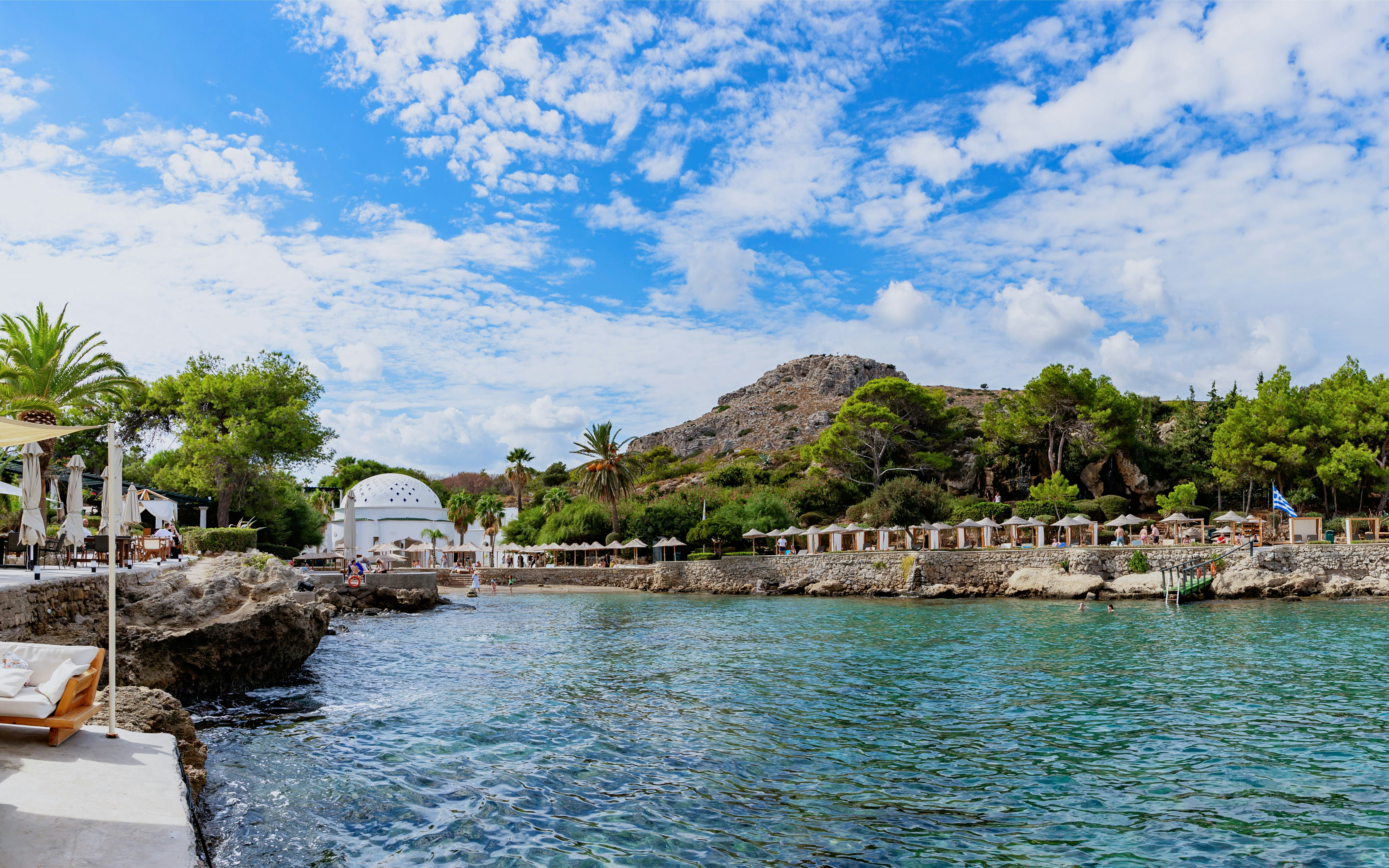 Kallithea Springs view with rocky shoreline and dome building during Rhodes cruise, Greece.