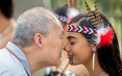 Man and woman sharing a hongi at Te Puia, New Zealand, during Te Rā Guided Experience.