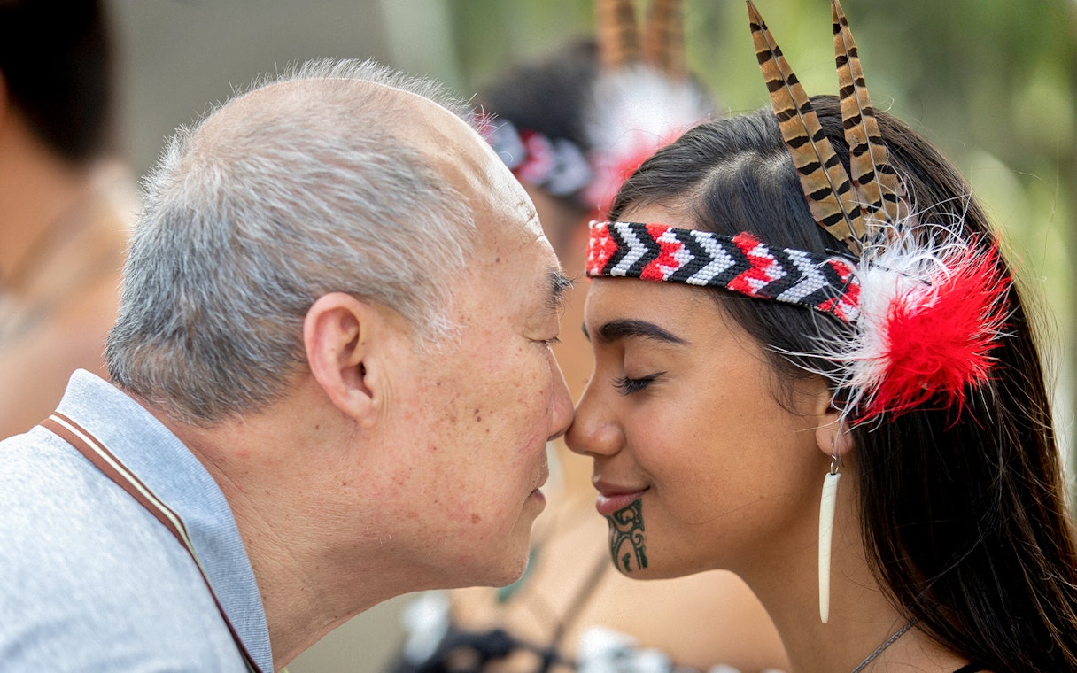 Man and woman sharing a hongi at Te Puia, New Zealand, during Te Rā Guided Experience.