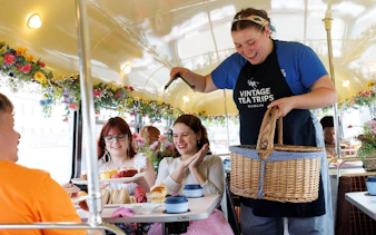 Guests enjoying afternoon tea on a vintage bus tour in Dublin.