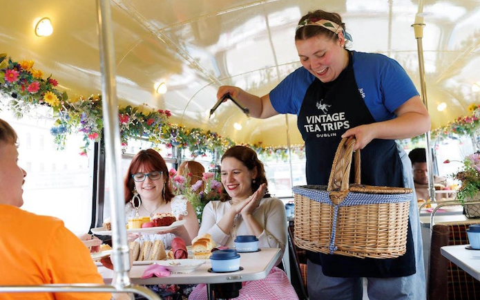 Guests enjoying afternoon tea on a vintage bus tour in Dublin.