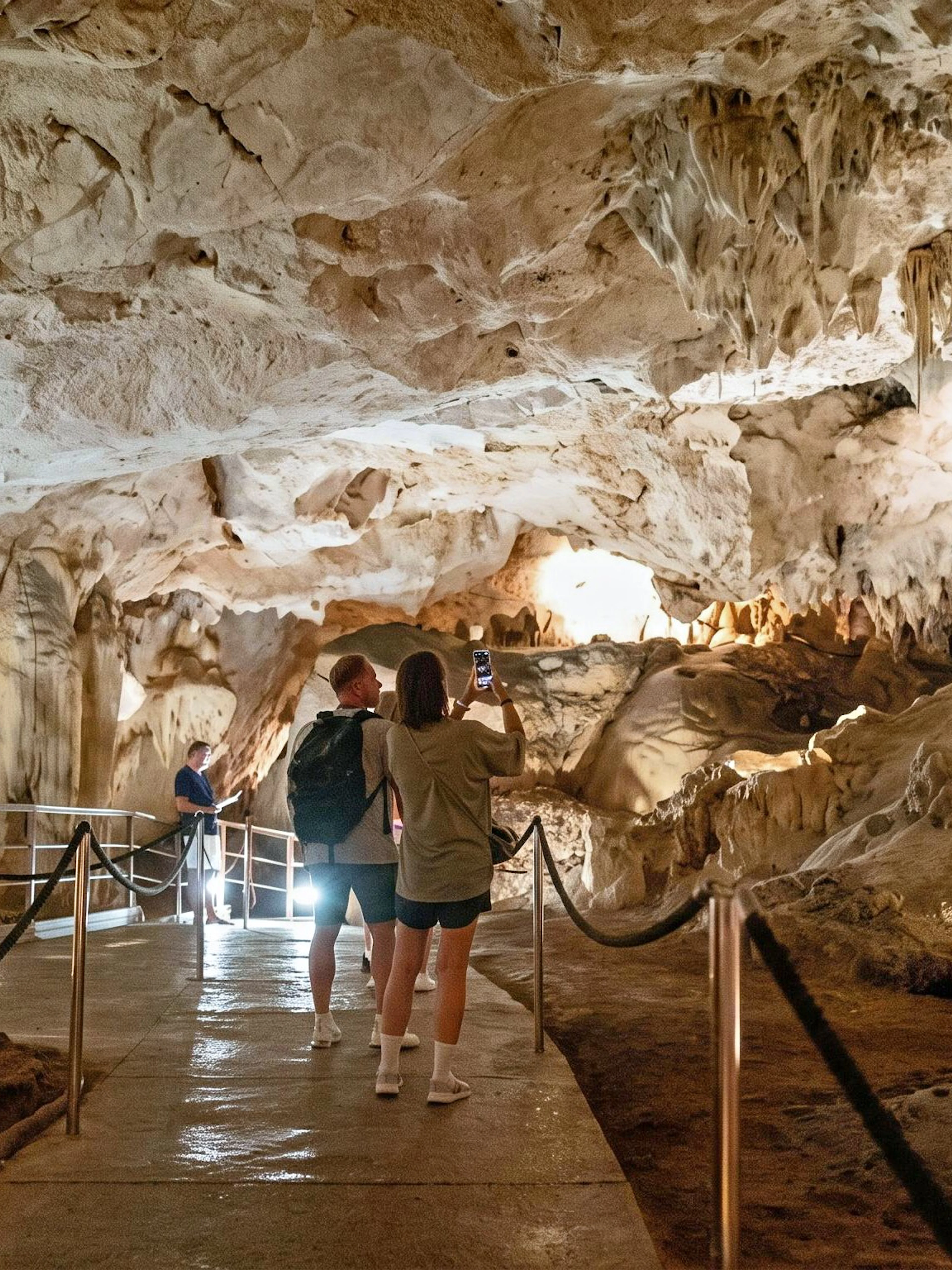 Visitors exploring the illuminated stalactites and stalagmites in the Caves of Nerja, Spain.