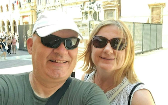 Couple enjoying Bologna city exploration game near historic architecture.